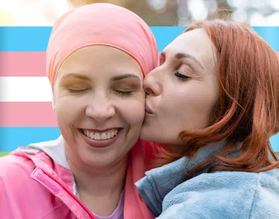 Two people in front the pink, blue and white flag