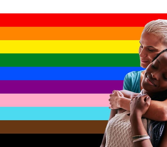 Two people in front of coloured strips of pride flag.