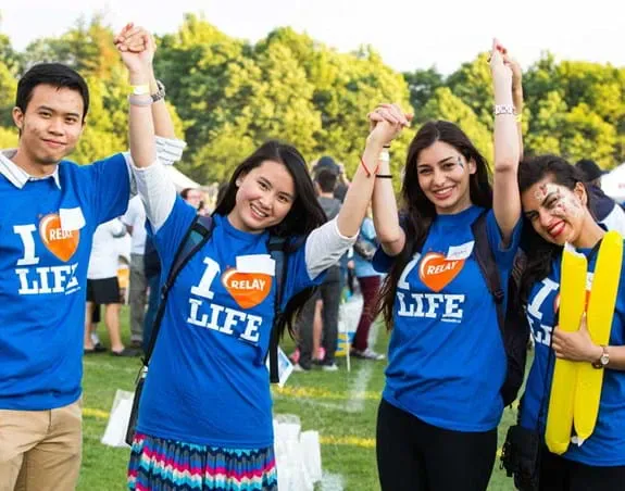 Four Relay For Life participants in blue shirts looking forward and smiling