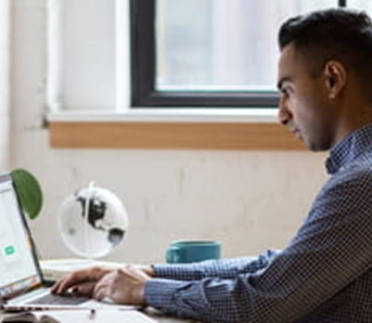 A man types on a laptop