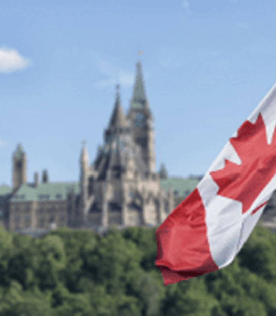 Le drapeau canadien flottant et, à l’arrière-plan, la Colline du Parlement