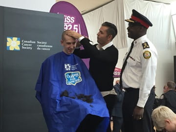 Andrew Stewart having his head shaved at a fundraiser.