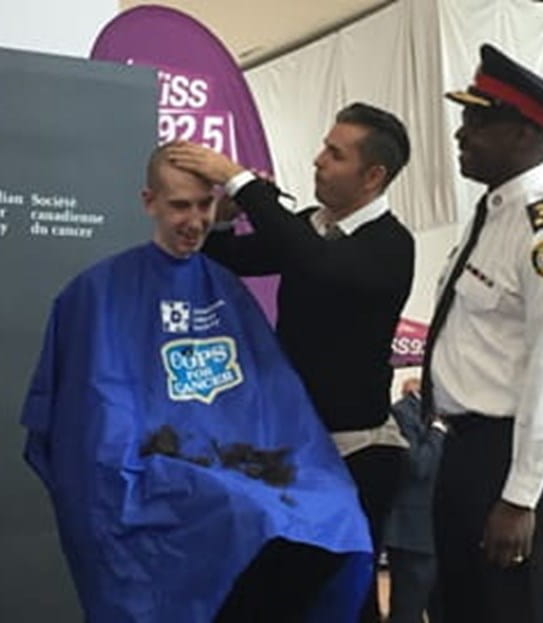 Andrew Stewart having his head shaved at a fundraiser.