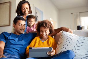 A family sitting together and looking at a laptop