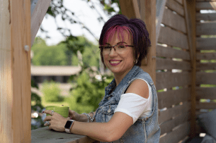 Bonnie, Breast Cancer Survivor, holding a mug and smiling