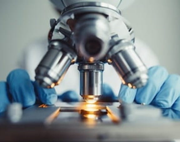 A researcher using a microscope.