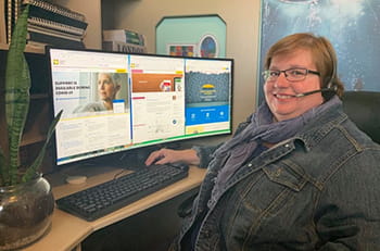 Carrie Van Lingen, Cancer Information Specialist, sitting at a computer.