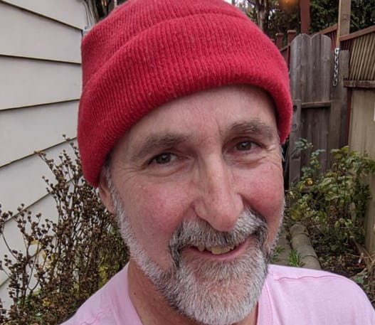 Photo of a smiling man with a red hat 