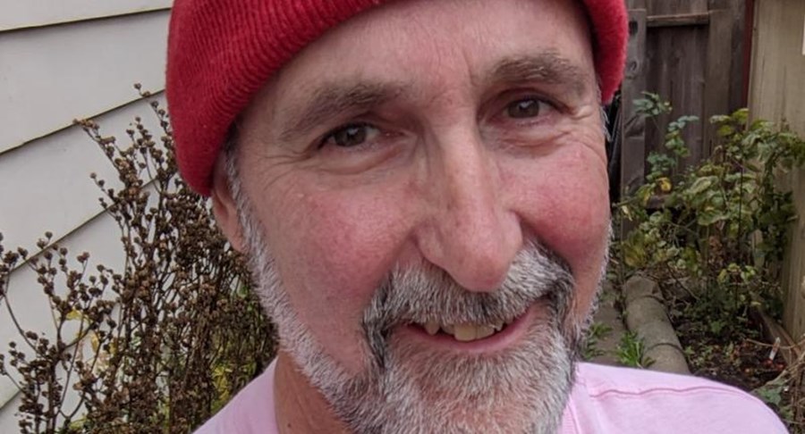 Photo of a smiling man with a red hat
