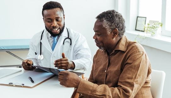 Un médecin et un patient âgé examinent ensemble un scanner