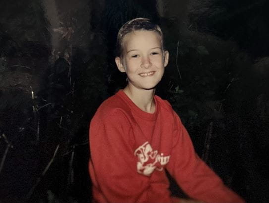 Sparkey looking and smiling at the camera when he was a camper at Camp Goodtimes