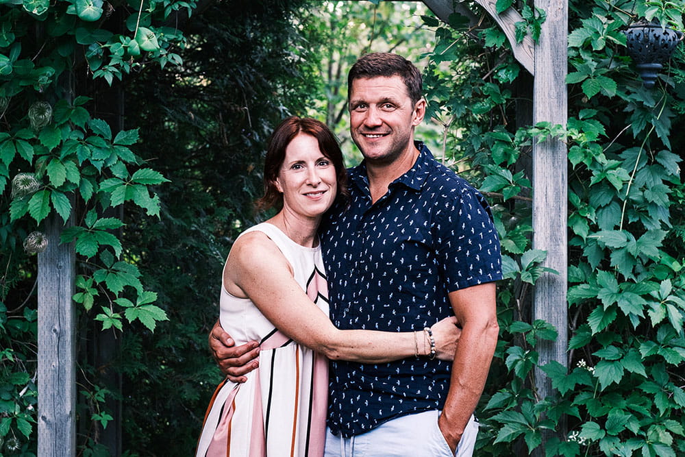 Laura hugging their partner in a garden