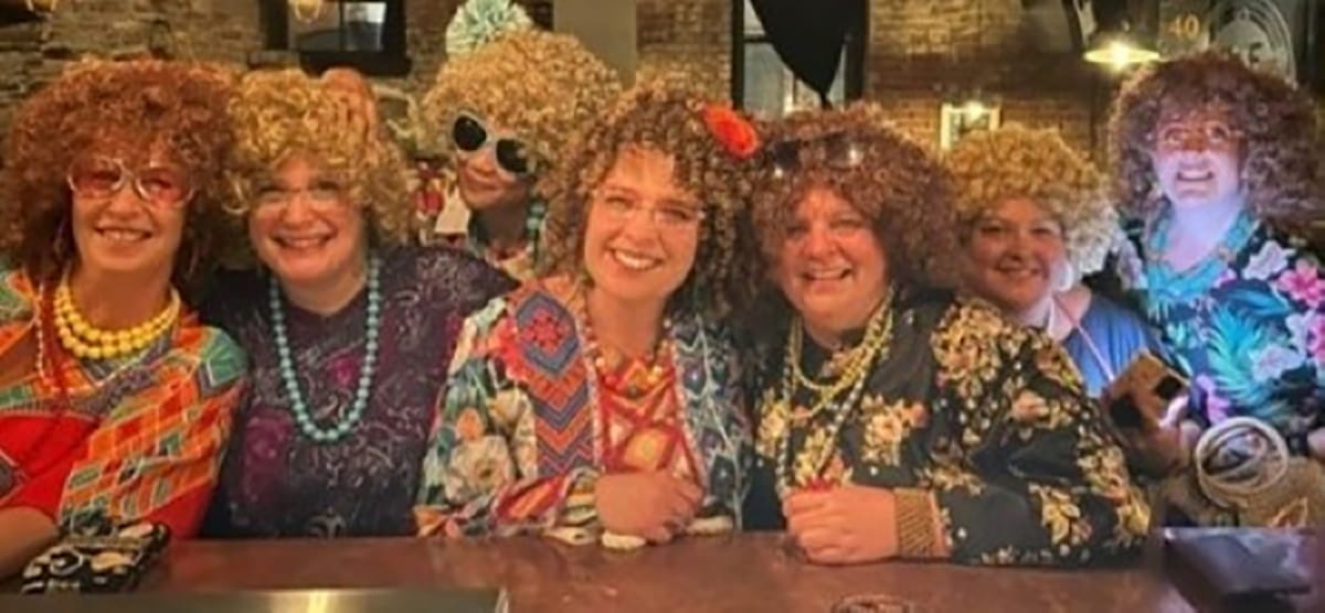 Des personnes déguisées en personnages de la comédie télévisée Vivre à trois prennent la pose.