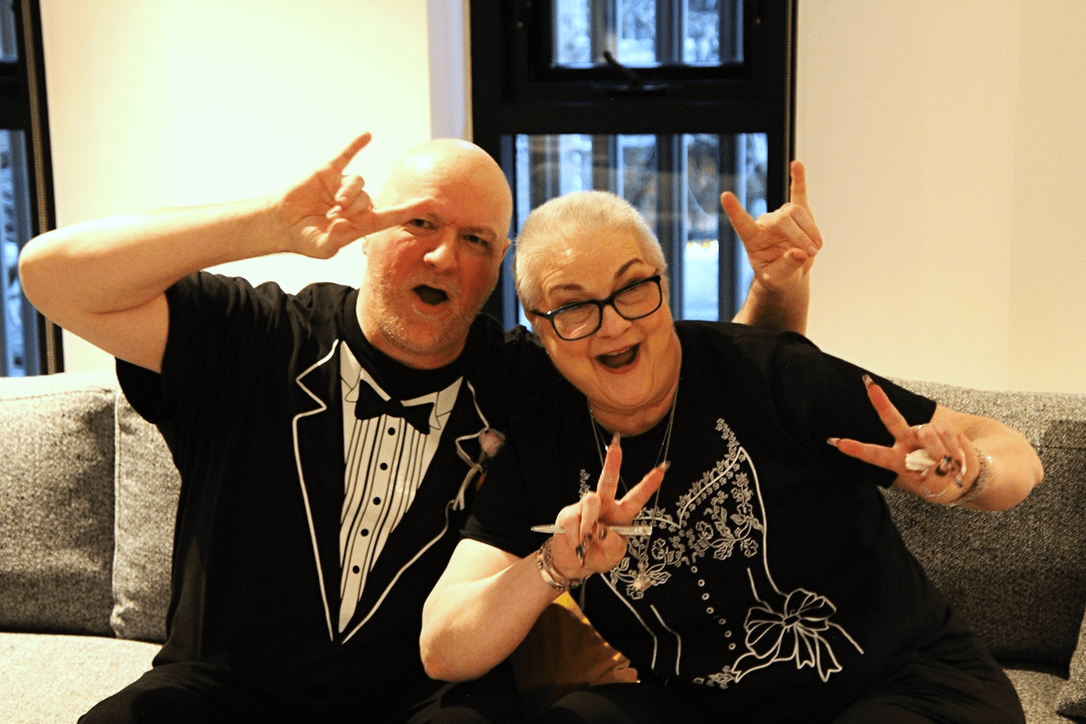 Chris and Sarah hold up horns and peace signs as they celebrate getting married.