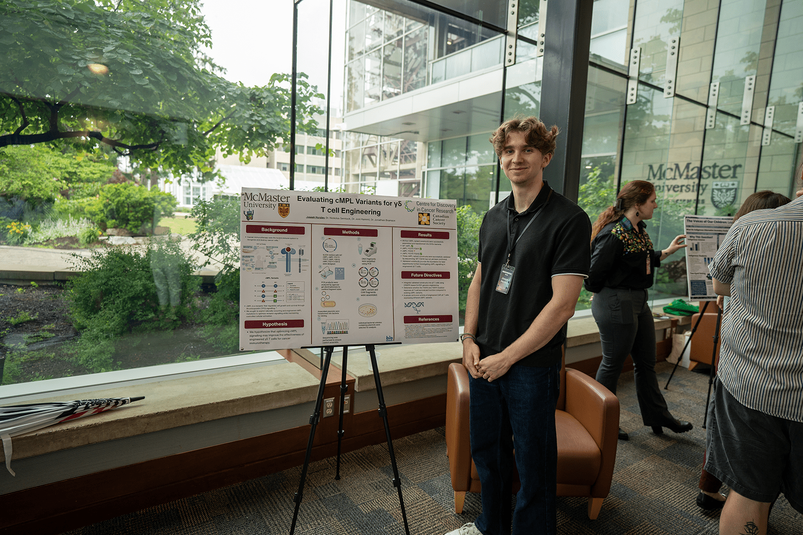 IndigiNerds participant Joseph Horsley stands beside his research poster.