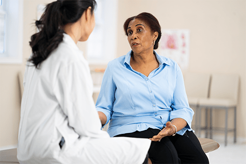 Une femme dans la cinquantaine discute avec son médecin.