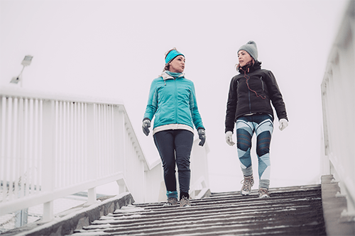 Two women walking down stairs lightly covered in snow