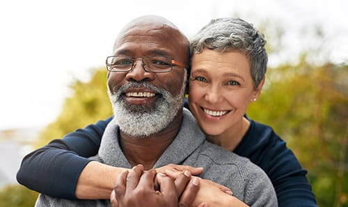 Older couple embracing and smiling.