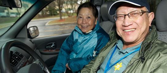 Two Wheels for hope drivers in the driver's seat and passenger's seat of a car.