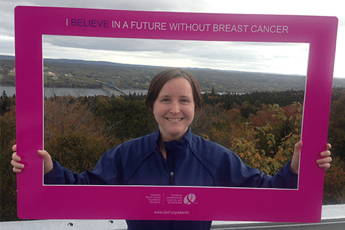 Kimberley holding up a pink breast cancer awareness frame.