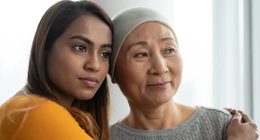 A cancer patient being hugged by their caregiver