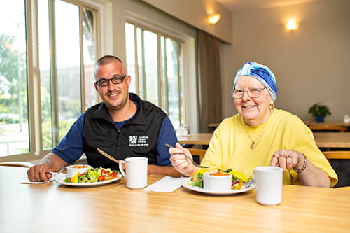 Deux invités dans une maison d’hébergement en train de manger un repas nutritif