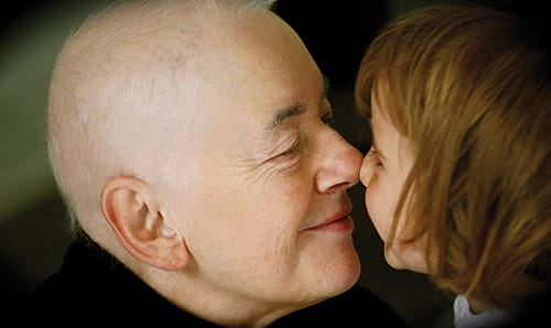 Person undergoing cancer treatment touching noses with girl.