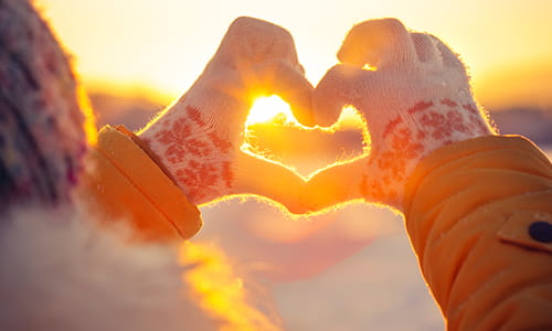 A person making a heart symbol with their hands