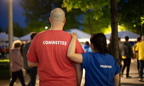 A photo of a man and a woman wearing volunteer t-shirts  