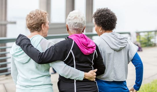 Three female friends with their arms around each other 