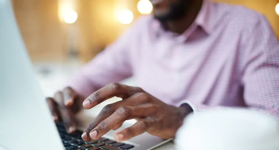 Un homme sur un ordinateur portatif faisant la recherche en ligne