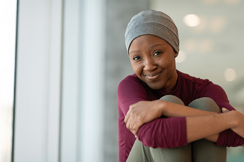 A woman sitting with her legs crossed and smiling