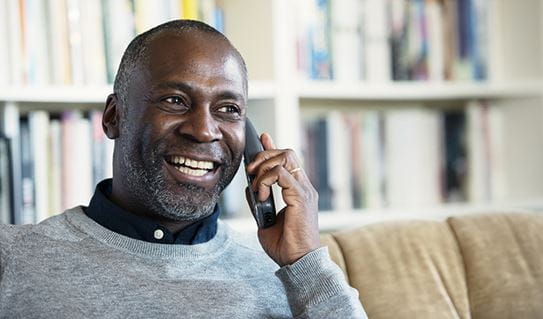 A man smiling while on the phone