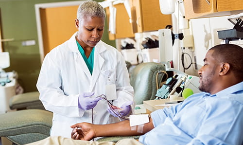 A doctor checking up on a patient receiving intravenous therapy.