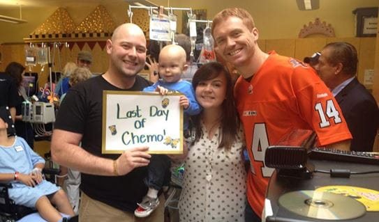 Aeson and his parents celebrates his last day of chemotherapy with Canadian football quarterback, Travis Lulay.