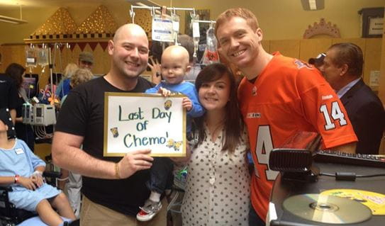 Aeson and his parents celebrates his last day of chemotherapy with Canadian football quarterback, Travis Lulay.