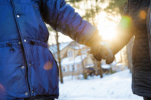 A close up of people holding hands in winter
