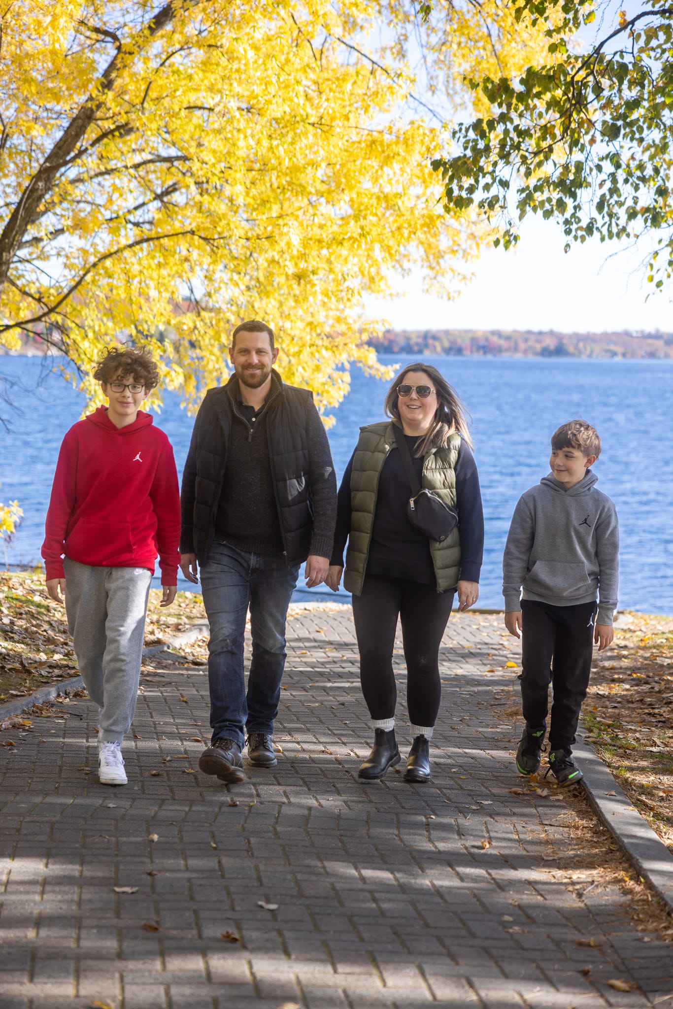 Tyler walking with his wife and sons in front of a lake.