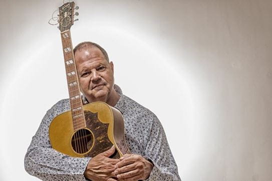 Jeff holding an acoustic guitar