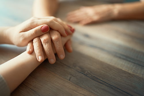 A friend’s hand on top of another friend’s hand