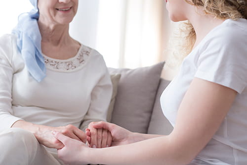 Two women facing each other and holding hands