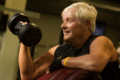 Jack smiling while lifting a weight at the gym