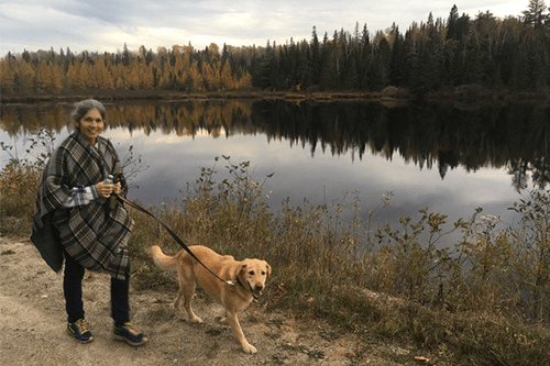 Kim walking her dog by a lake