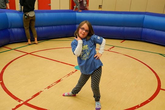 Une petite fille debout sur un terrain de basket-ball, posant, la main sur la hanche.