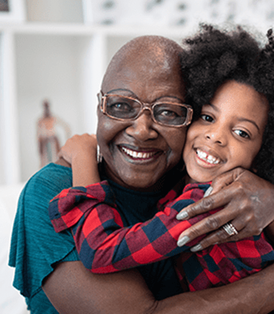 A grandmother hugging her granddaughter.