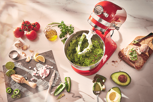 A stand mixer with guacamole in a bowl
