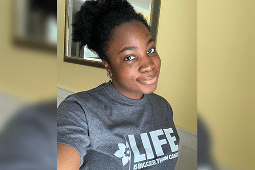 A selfie of Precious wearing a “life is bigger than cancer” t-shirt.