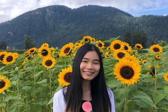 Rachel, une bénévole de la Société canadienne du cancer, dans un champ de tournesols.