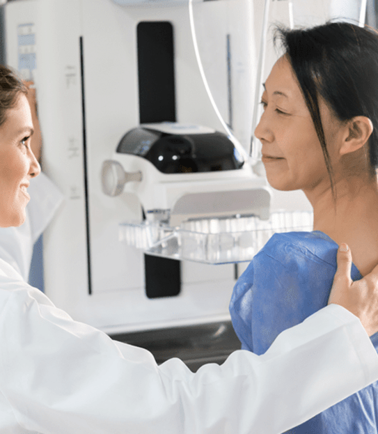 Woman getting a breast screening from a female doctor.