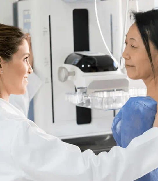 Woman getting a breast screening from a female doctor.